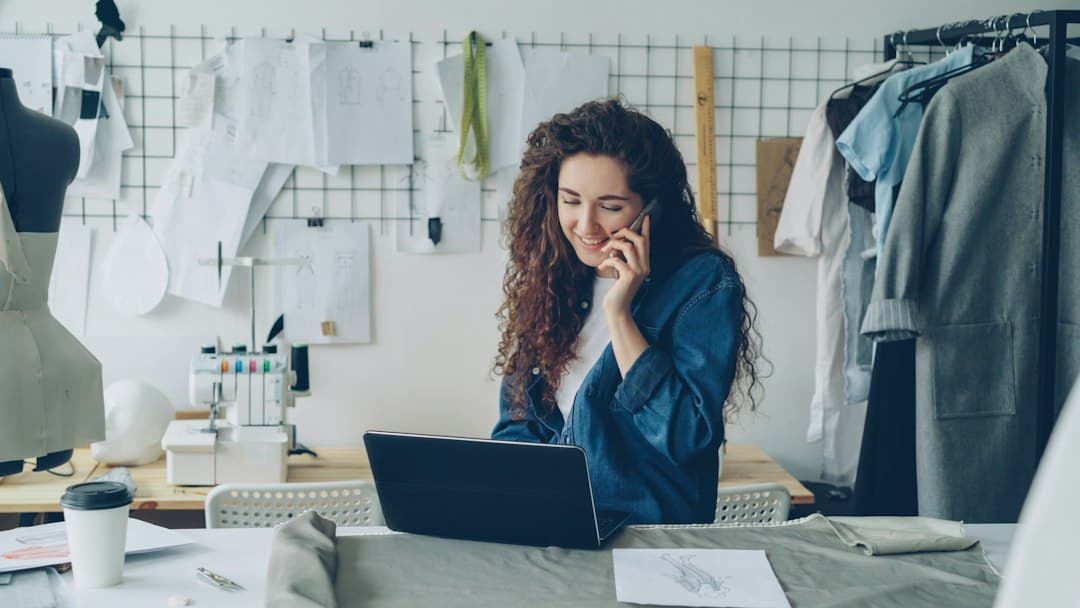 Small business owner on the phone while working on a laptop in her studio