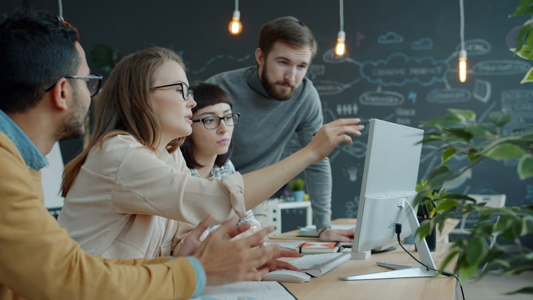Small team gathered around a computer screen in an office