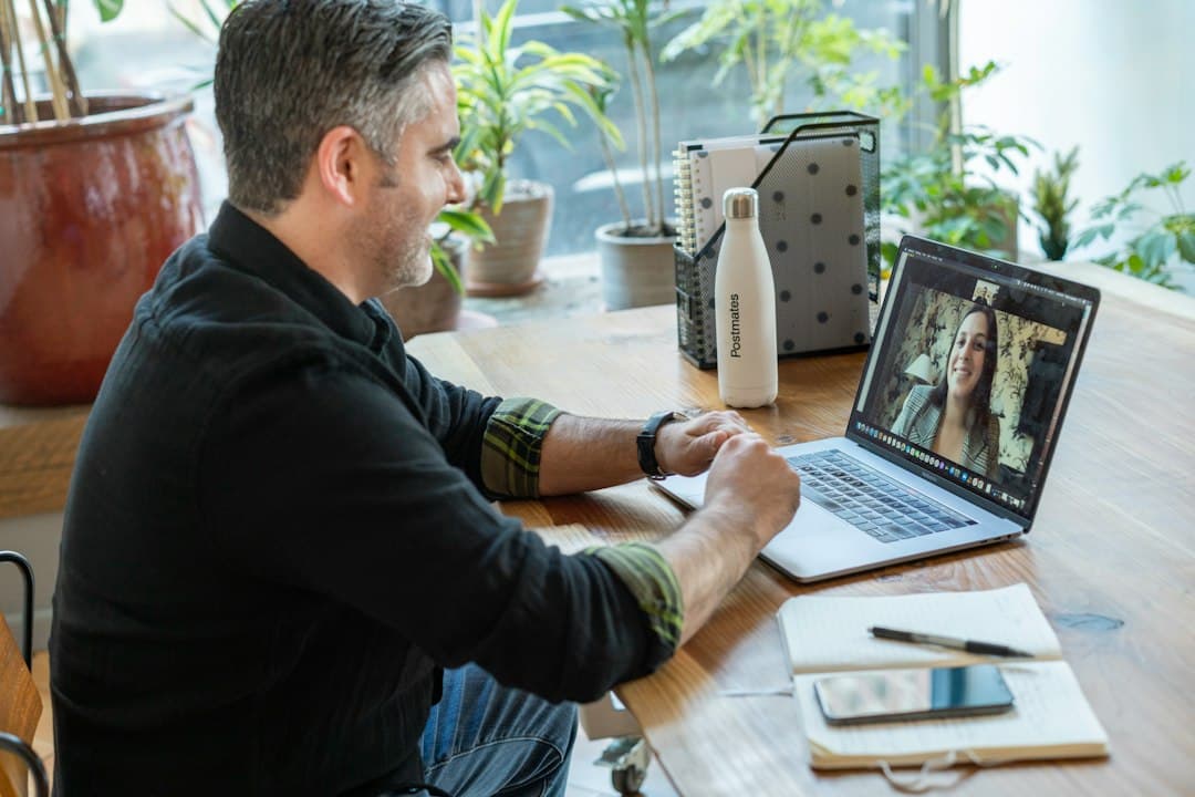 Man on a video call at a laptop in a bright office
